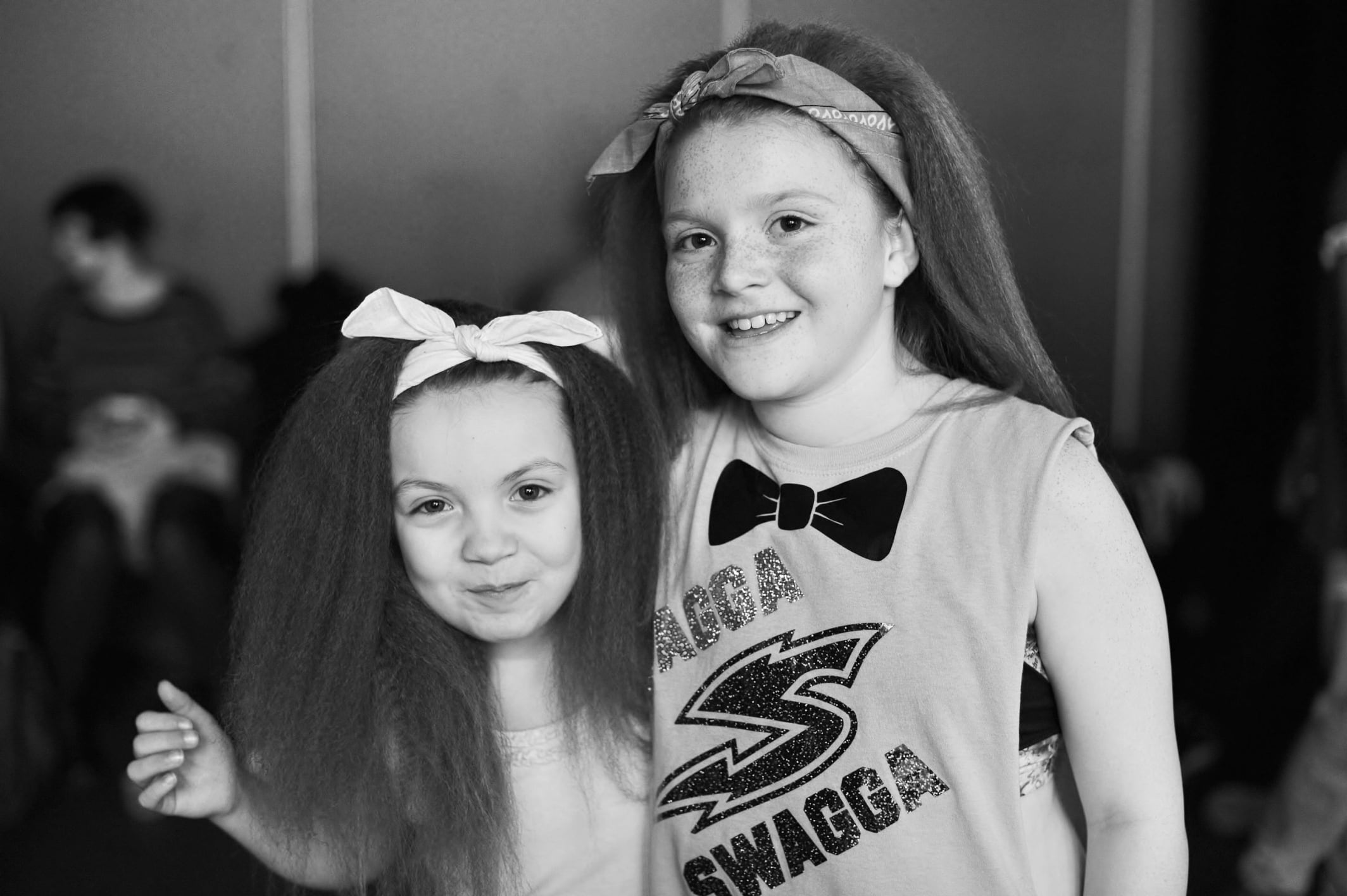Two girls in black and white, smiling at the camera